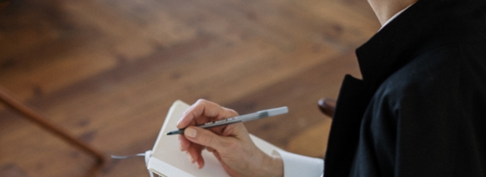 a person holding a pen and notebook